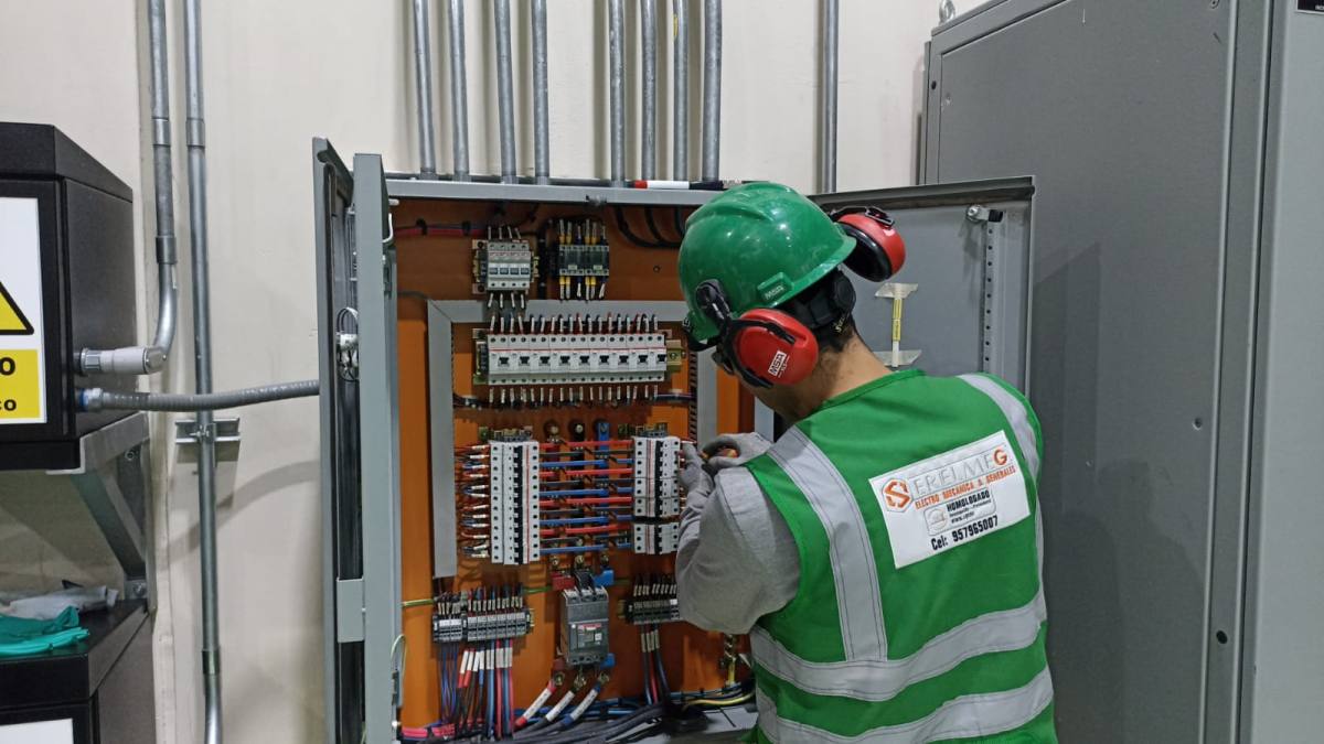 Técnico de SERELMEG realizando mantenimiento en un tablero eléctrico industrial